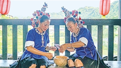     程陽橋上，侗族婦女在展示制作侗族刺繡產品。繡品圖案精美、色彩艷麗，成為當地特色產業。